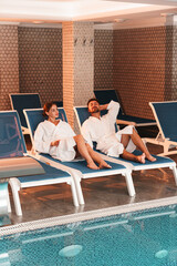 Happy young couple enjoying treatments and relaxing at wellness spa center