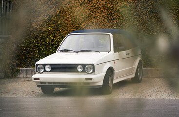 White Retro Cabriolet, an Iconic 80s European Convertible, Graces the Open Road. Retro cabriolet....