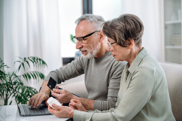 senior couple buying medication online with bank card