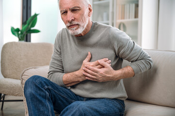 mature man feeling cardiac pain in chest
