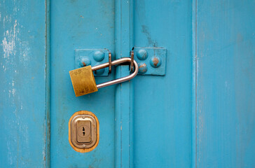 Turquoise wooden door with a padlock