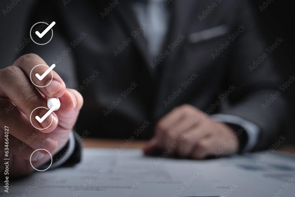 Poster Businessman using pen to tick correct sign mark in checkbox for quality document control checklist ,document approve and business approve project concept.