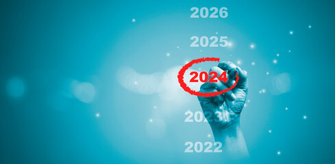 Hand drawing circle to mark red number 2024 with copy space and bokeh for preparation merry...