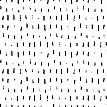 Rough seamless pattern with brush stripes and thin strokes. Black vertical doodle dashes on white background. Hand painted grunge texture. Dry smears and short brushstrokes. Modern vector background