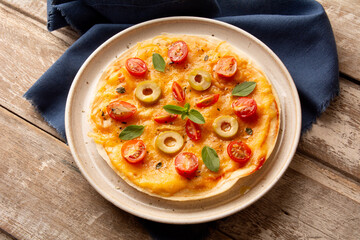 Cheese with tomatoes and basil pizza pan in a handmade ceramic plate in top view