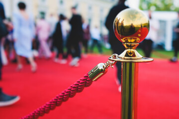 Red carpet with ropes and golden barriers on luxury party entrance, cinema premiere film festival event award gala ceremony, wealthy rich guests arriving, outdoor decoration elements, summer day