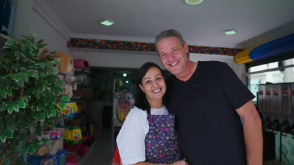 Fototapeta na wymiar Joyful Couple Owners of Small Business smiling and laughing together while standing in front of storefront. Authentic real life people entrepreneurs of PetShop