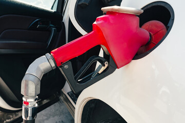 Filling a car with fuel at a gas station. The car fills up with gasoline at a gas station. Gas...