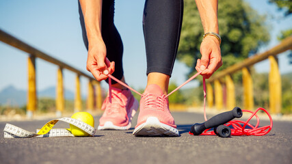 Woman tying laces- sport,active lifestyle,fitness, wellness concept - obrazy, fototapety, plakaty