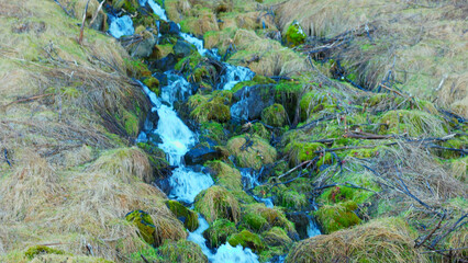 Water stream from icelandic waterfall running down off of cliff, river flow falling off mountain or hill in reykjavik. Majestic natural seljalandsfoss cascade in iceland, nordic scenery.