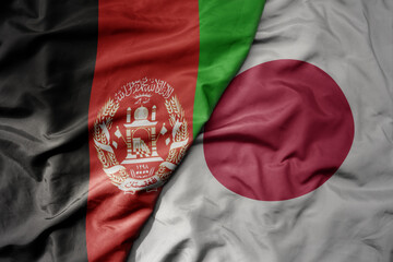 big waving realistic national colorful flag of afghanistan and national flag of japan .