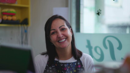 Portrait of a happy female Entrepreneur owner of small business behind counter wearing apron