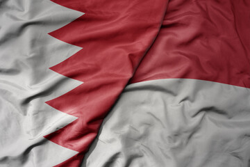 big waving realistic national colorful flag of bahrain and national flag of indonesia .