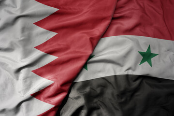 big waving realistic national colorful flag of bahrain and national flag of syria .