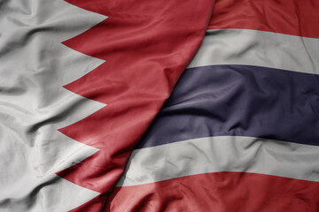 big waving realistic national colorful flag of bahrain and national flag of thailand .