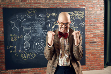 Excited young man, scientist feeling happy and delightful, successful researchers. Formulas on...