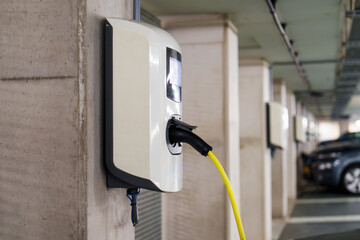 Recharging electric cars at the charging station in the underground parking. The concept of ecological energy systems. Electric cars in an underground car park at a charging station