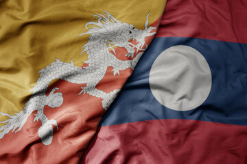 big waving realistic national colorful flag of bhutan and national flag of laos .