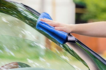 a man wipes the car window