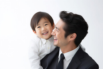 asian business man's face lights up with a warm smile and looking affectionately at his child. They share a joyful moment, embodying harmony of professional success and patural love of a father