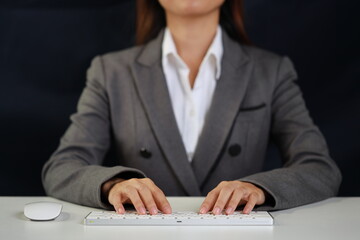 Attractive female hands in classing suit using laptop computer keyboard searching, browsing internet data online information. Lifestyle with technology