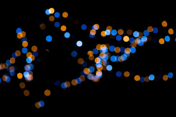 Blue and yellow festive bokeh lights on black background