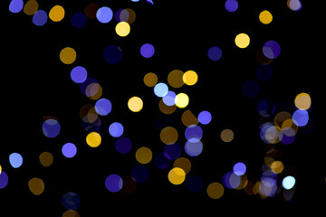 Blue and yellow festive bokeh lights on black background