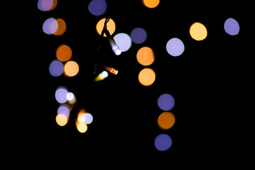 Blue and yellow festive bokeh lights on black background