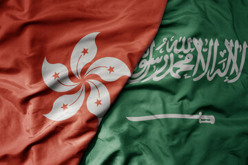 big waving realistic national colorful flag of hong kong and national flag of saudi arabia .