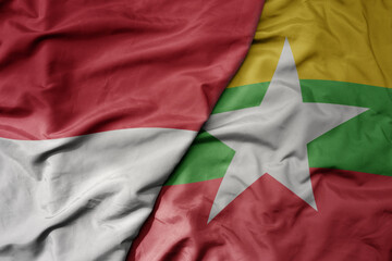 big waving realistic national colorful flag of indonesia and national flag of myanmar .