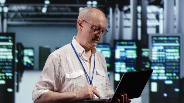 Focused IT support executive in data storage company equipped to handle complex computational operations, doing checking on server devices, verifying efficiency parameters to prevent liabilities