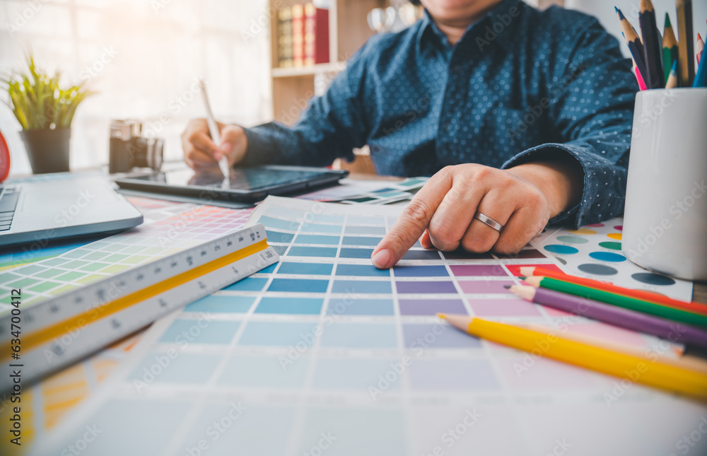 Poster graphic designer architects who work with laptops and color comparison tables for design work..