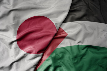 big waving realistic national colorful flag of japan and national flag of palestine .