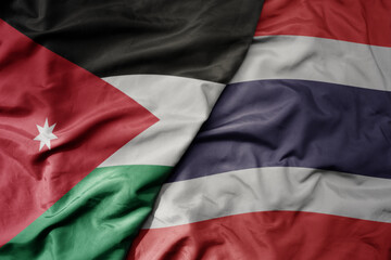 big waving realistic national colorful flag of jordan and national flag of thailand .