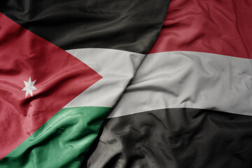 big waving realistic national colorful flag of jordan and national flag of yemen .