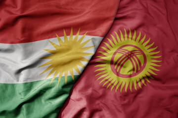 big waving realistic national colorful flag of kurdistan and national flag of kyrgyzstan .