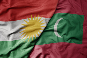 big waving realistic national colorful flag of kurdistan and national flag of maldives .