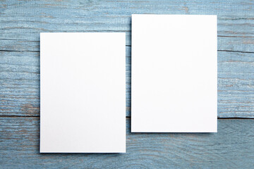 Blank invitation card mockup, two white greeting cards on blue wooden background. Invite mockup,...