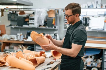 Using marker to draw the line. Technician working with prosthesis in modern laboratory