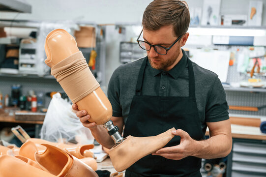 Leg prosthesis in hands. Technician working indoors