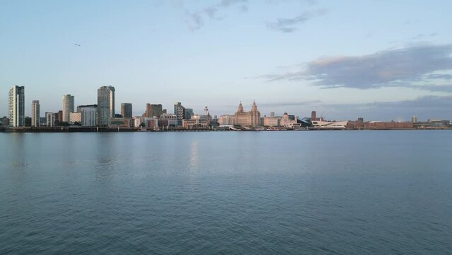 Very fast aerial approach over water towards Liverpool skyline, Merseyside, England