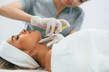 Obraz na płótnie Canvas Syringe for a rejuvenating injection. Woman face getting facial care by beautician hands at spa salon