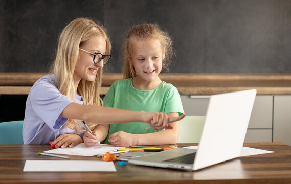 Alternative Pedagogy. A young woman teacher is engaged in individual lessons with a toddler girl. Online classes through a laptop, online lessons at distance home learning. creative skills in a child