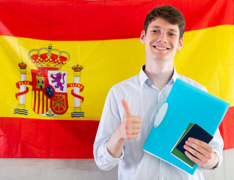 Positive student on background of flag of Spain - concept of studying abroad and immigration