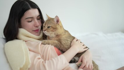 Beautiful young woman in casual clothes playing with her beloved pet at home.