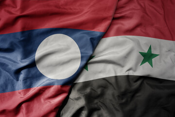 big waving realistic national colorful flag of laos and national flag of syria .