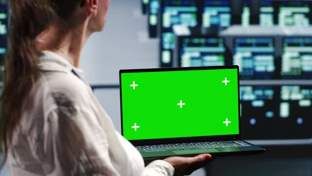 Trained IT consultant in server farm housing high end mainframes capable of quickly and efficiently performing complex computations and data analysis, using mockup laptop to clear risks