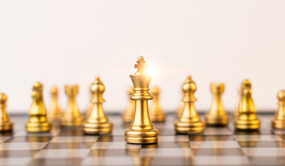 Leader, business strategy and planning concept, Gold Chess king figure on Chessboard and surrounded by a number chess pieces against opponent or enemy. Conflict, tactic, politic.