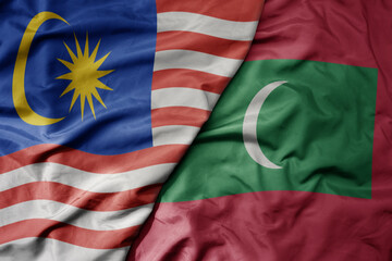 big waving realistic national colorful flag of malaysia and national flag of maldives .