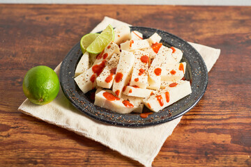 Mexican snack yam bean also called Jicama with chili powder and chamoy sauce